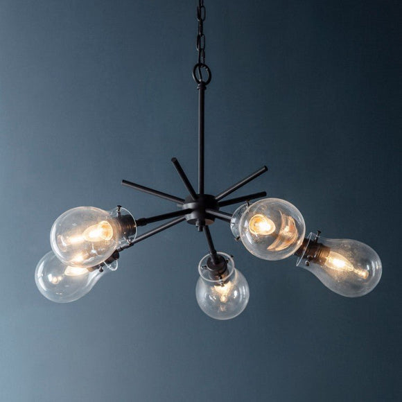 A modern black metal chandelier from KHEE, featuring five exposed clear globe light bulbs and a starburst design, suspended by a chain.