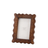 Wooden picture frame with scalloped edges on a white background