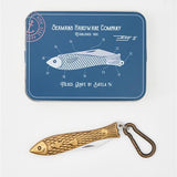 Fish-shaped knife with carabiner on a blue Seaman's Hardware Company card